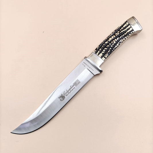 A Columbia brand tactical knife with a nylon sheath, featuring a silver-colored blade and black nylon handle with a textured grip.
