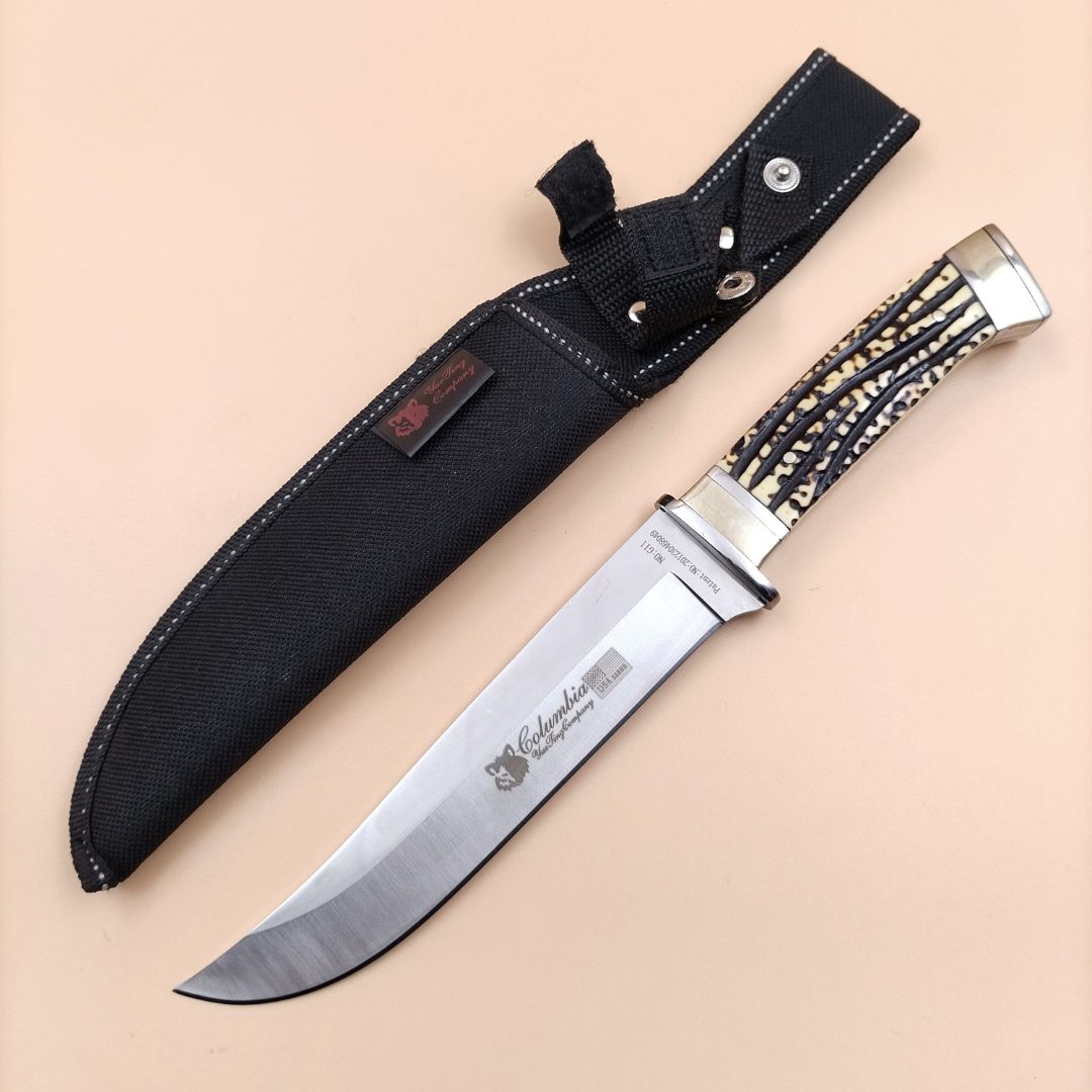 A Columbia brand tactical knife with a nylon sheath, featuring a silver-colored blade and black nylon handle with a textured grip.
