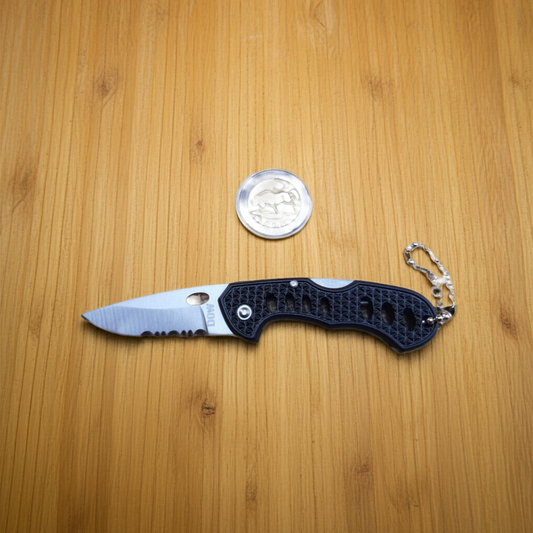 A folding knife with a black handle and silver blade, featuring a keychain attachment