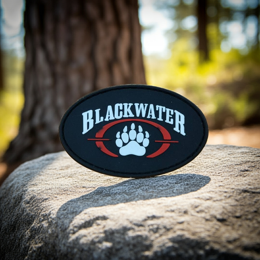 Blackwater logo patch on a rock with a forest background