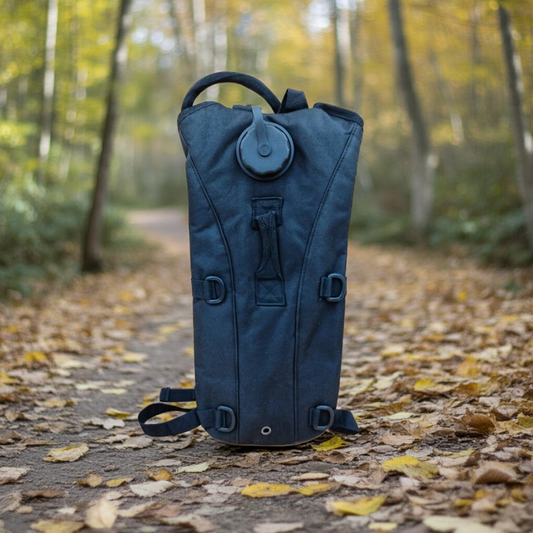 Black camel water bag on a forest path with autumn leaves