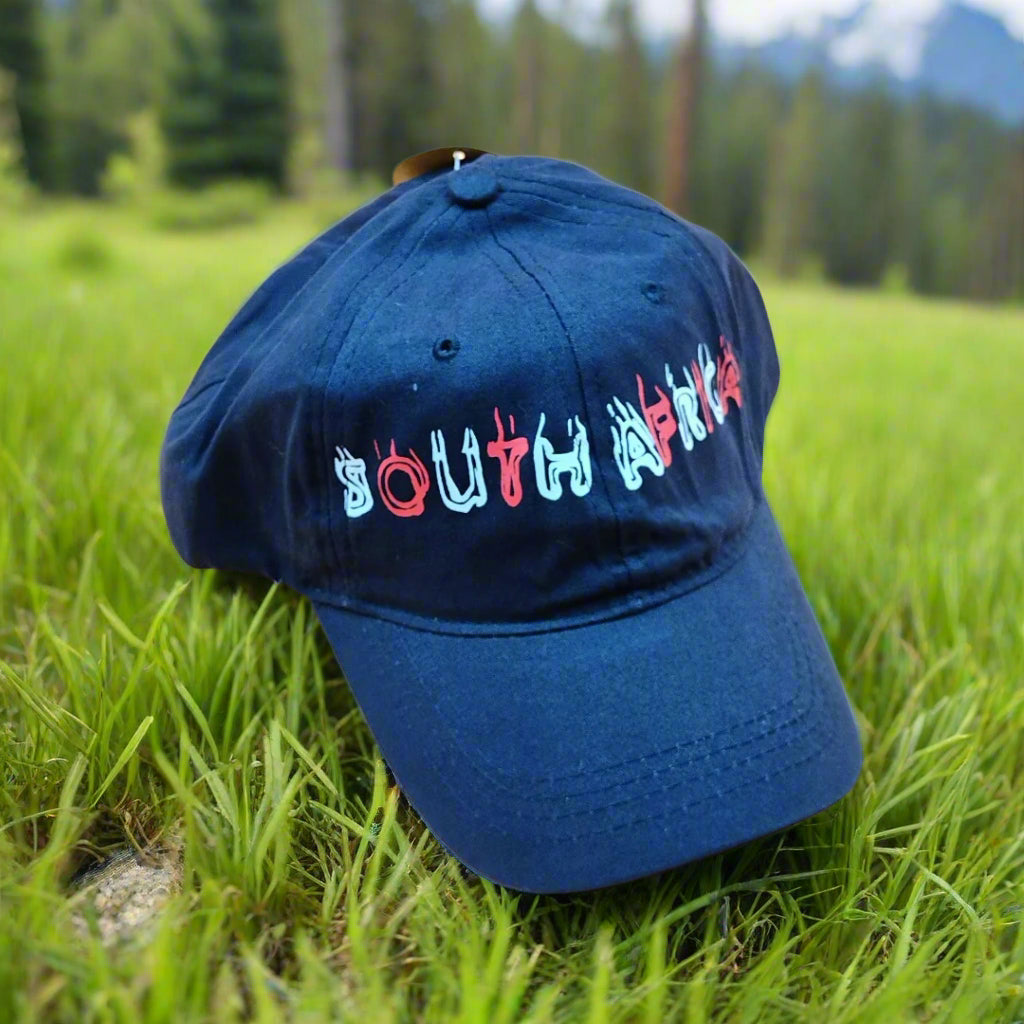 Blue cap with 'South Africa' text in colorful letters on grass