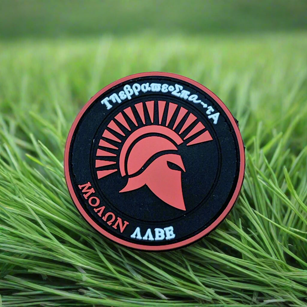 Round badge with Spartan helmet design on grass