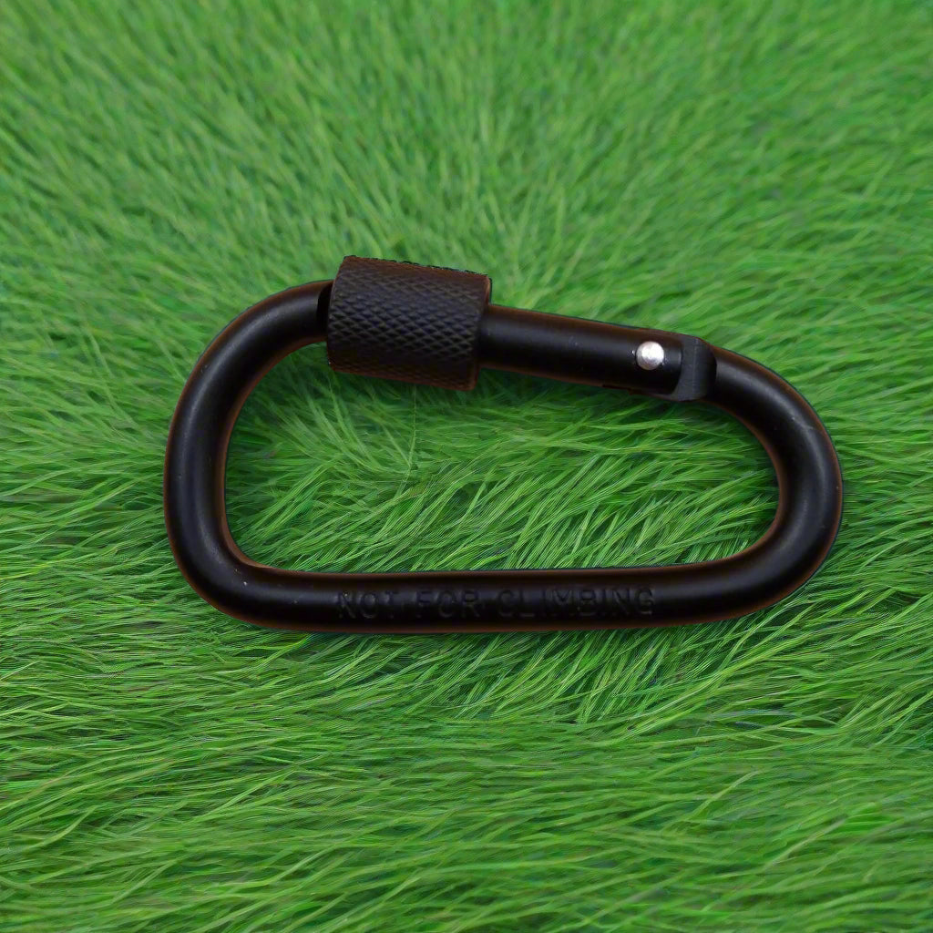 Black carabiner on a green textured surface