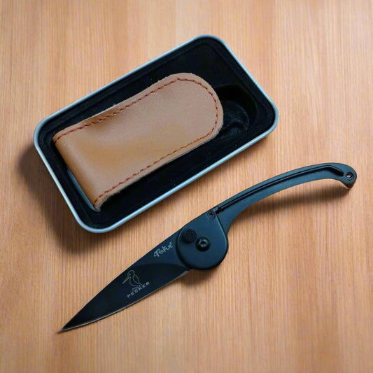 A black folding knife with a metal box and a brown leather belt sheath. The knife is partially open, displaying the blade and the handle.