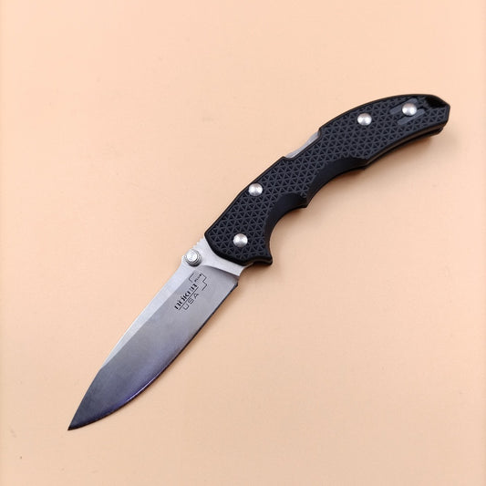 A black Boker Plus folder knife with a satin finish and a textured handle.