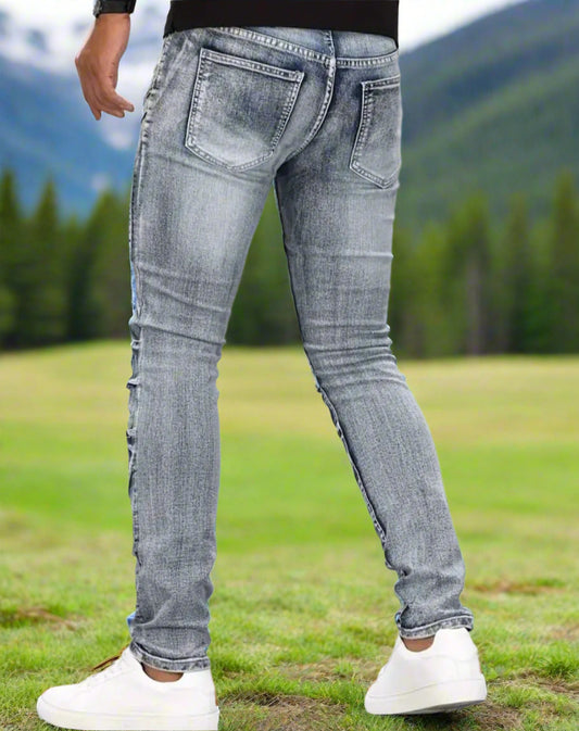 Person wearing light blue jeans with a blurred natural background