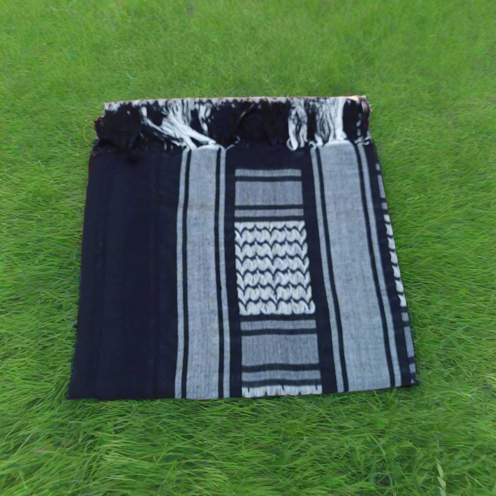 Black and white patterned towel shemagh surrounded by green grass
