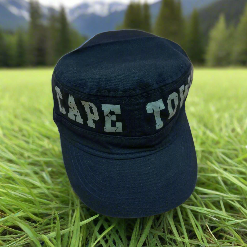 Black cap with 'CAPE TOWN' band on a beige background
