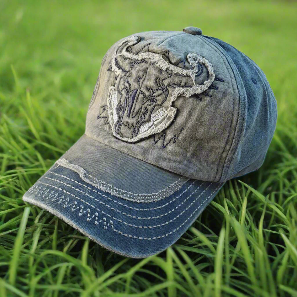 Blue denim cap with embroidered design on a white background