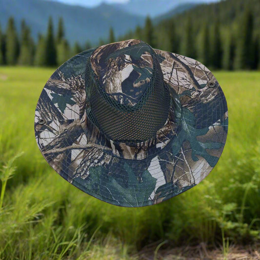 Camouflage-patterned hat in a grassy field with trees in the background