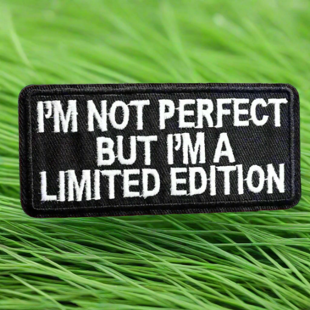 A black patch with the text 'I'm not perfect but I'm a limited edition' written in white.
