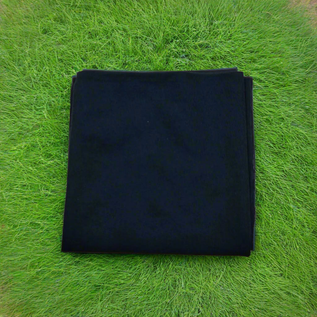 Folded black fabric on a beige background