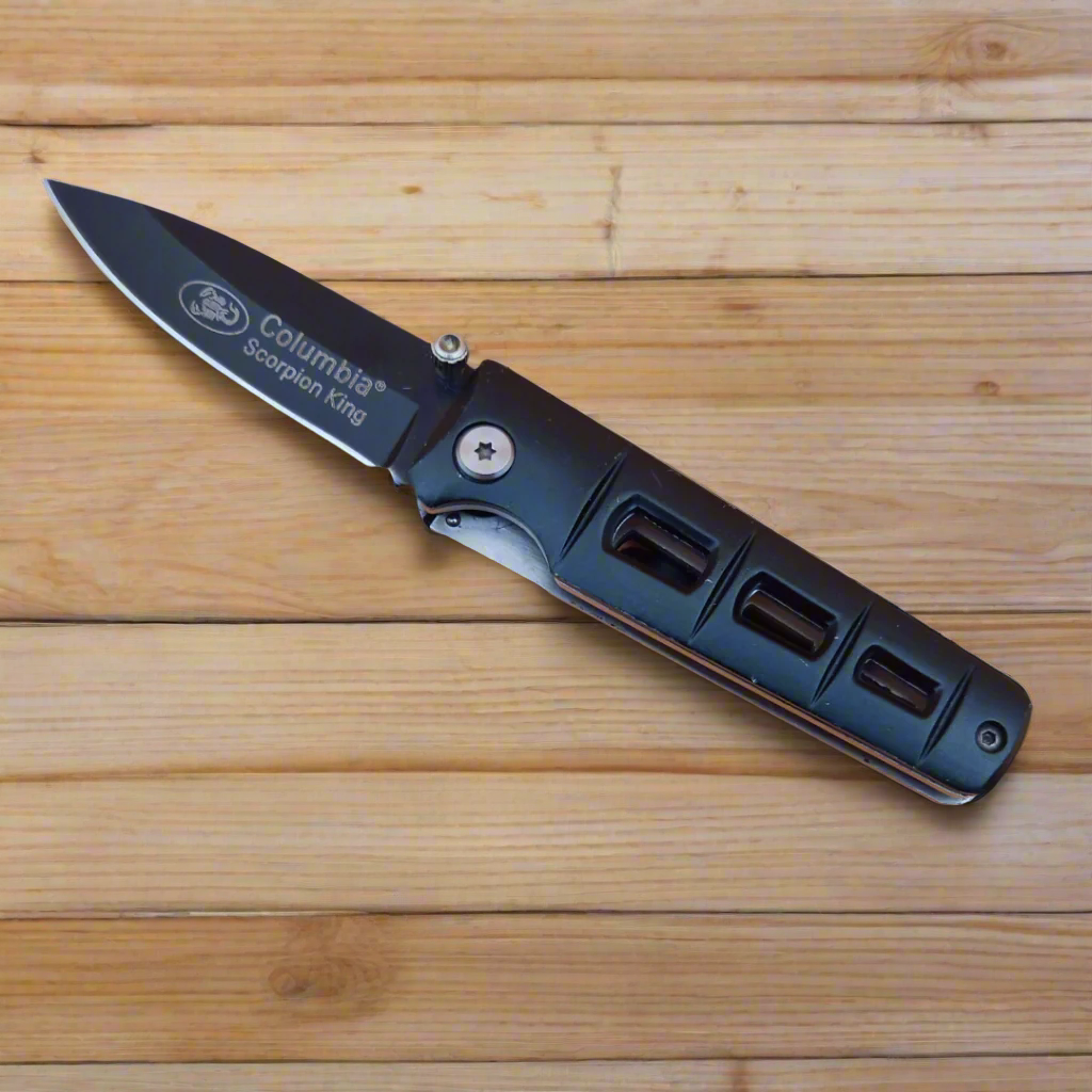 Folding knife with Columbia branding on a wooden surface