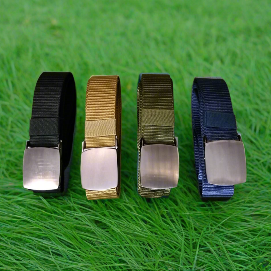 Four belts in black, khaki, green, and blue on a grass background