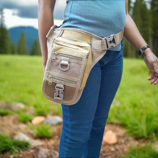 A person wearing a beige thigh pouch with multiple compartments and a removable holster, blue jeans, and a blue shirt.