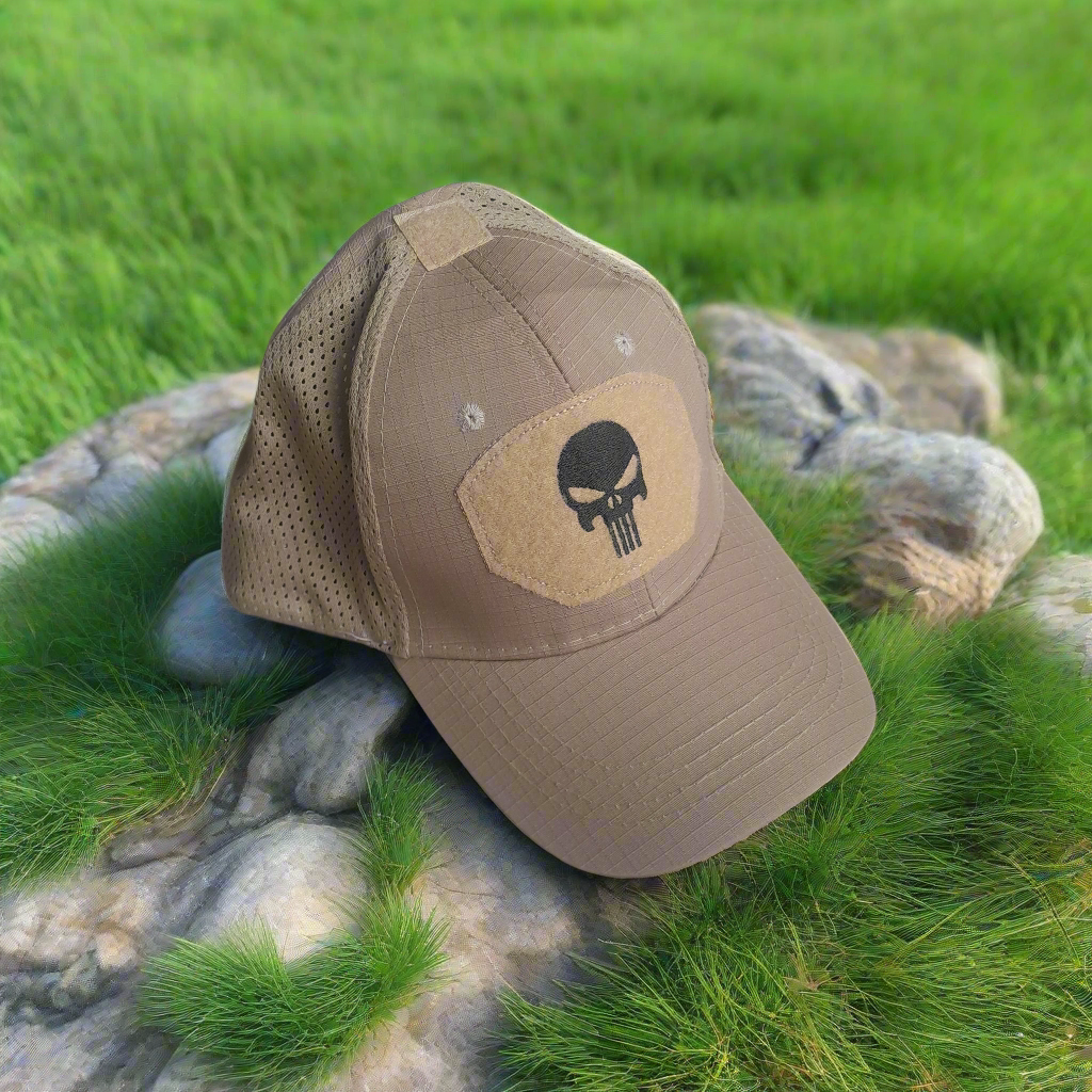 Khaki cap with a skull emblem on grass and rocks