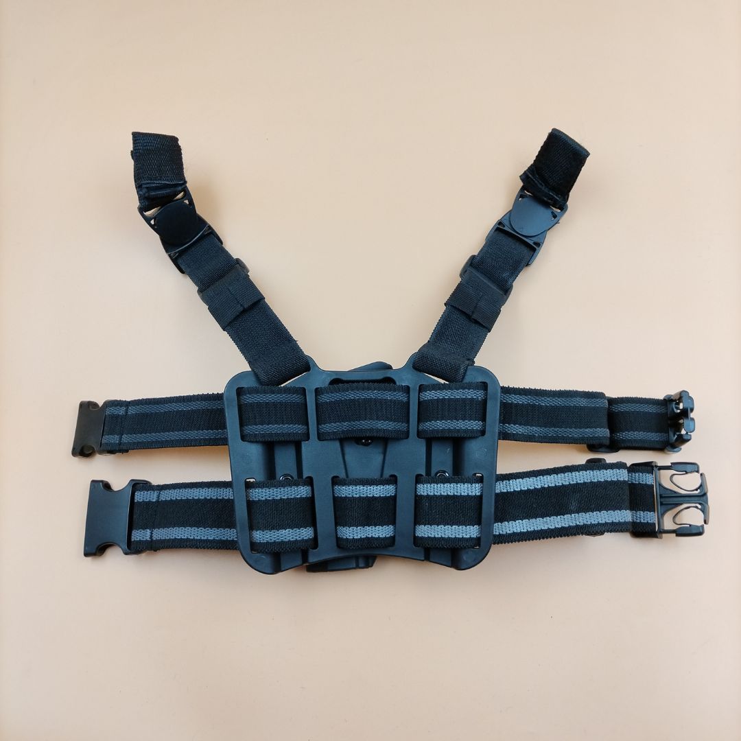 A black leg holster with a quick release button and additional pouches, designed for a Glock firearm.