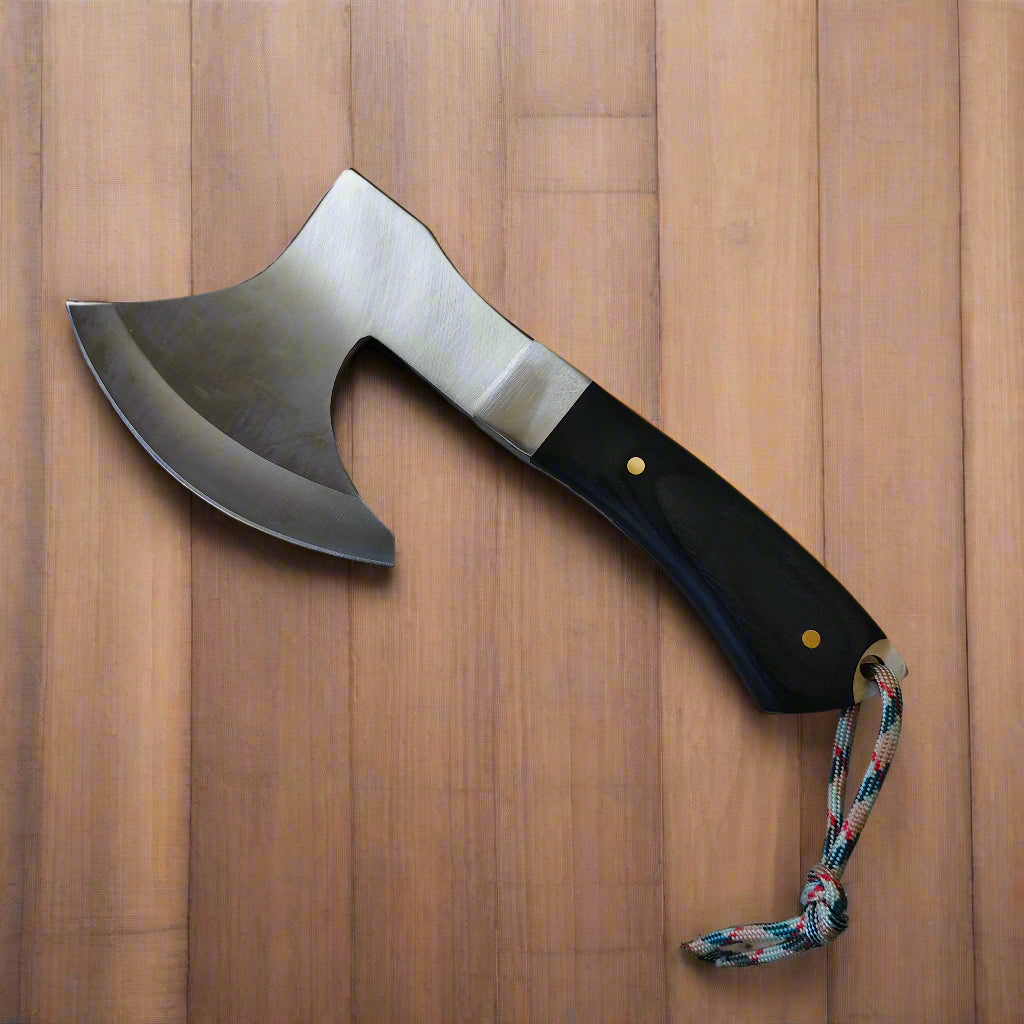 Axe with a black handle and colorful cord on a beige background
