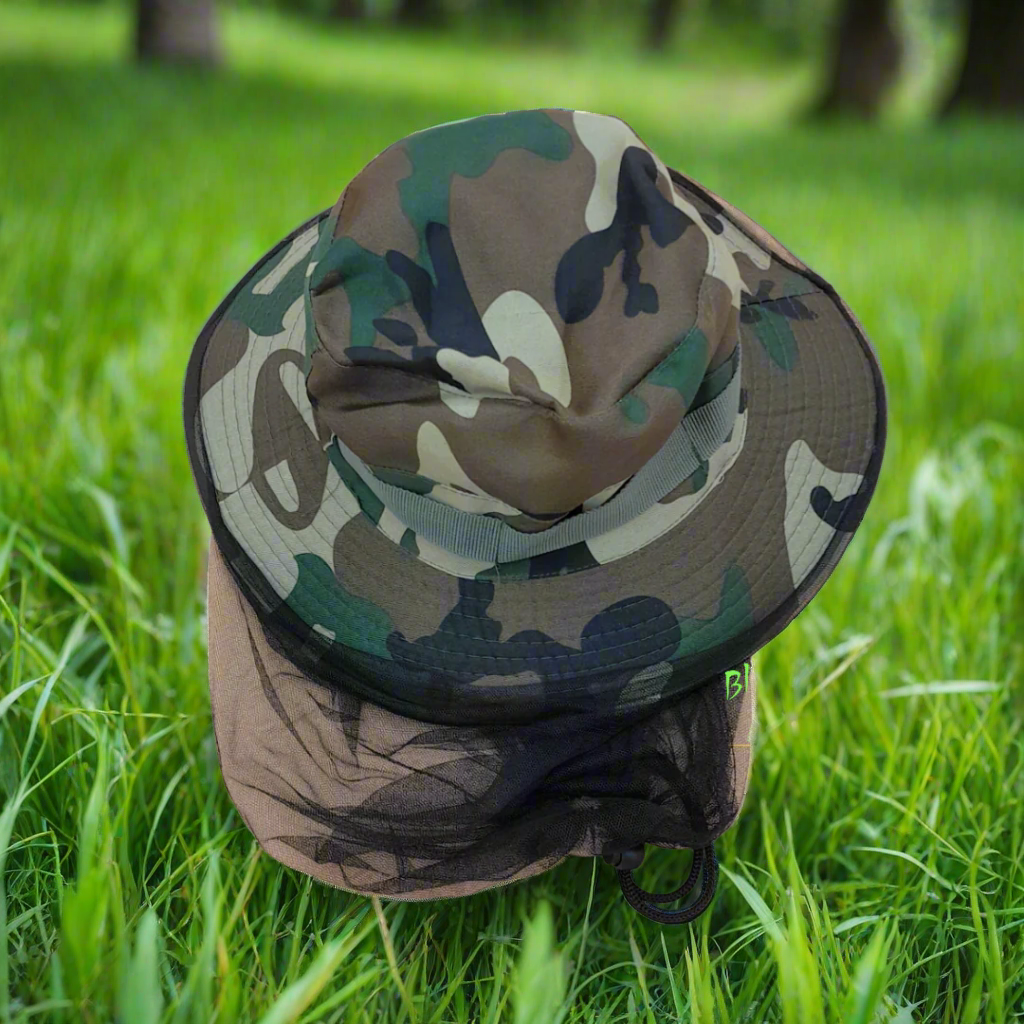 A mannequin head wearing a camouflage hat with a mosquito net attached to it.