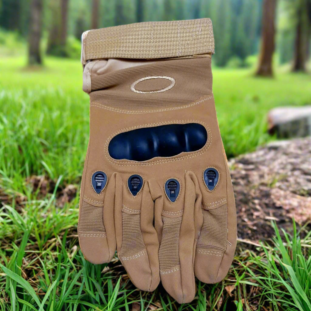 Tan tactical glove with black palm on grassy ground