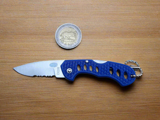 Blue pocket knife with keychain on a textured surface, next to a coin for scale.