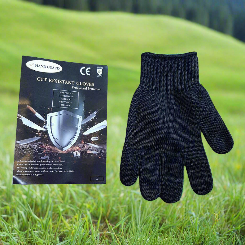 Black cut-resistant gloves with packaging on a textured surface