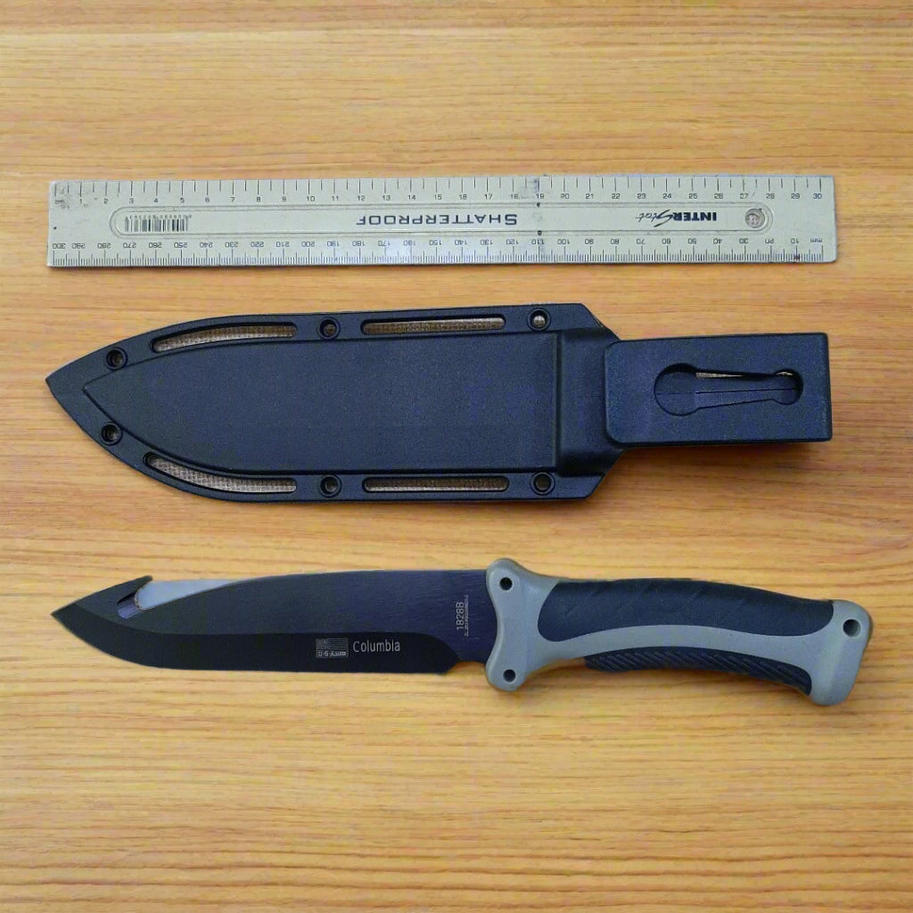 Knife with sheath and ruler on a textured surface