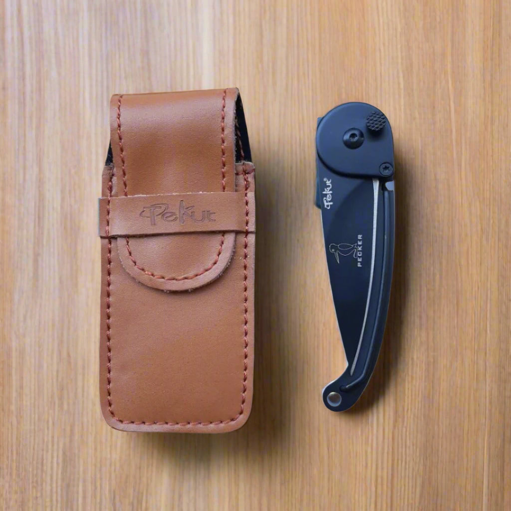 A black folding knife with a metal box and a brown leather belt sheath. The knife is partially open, displaying the blade and the handle.