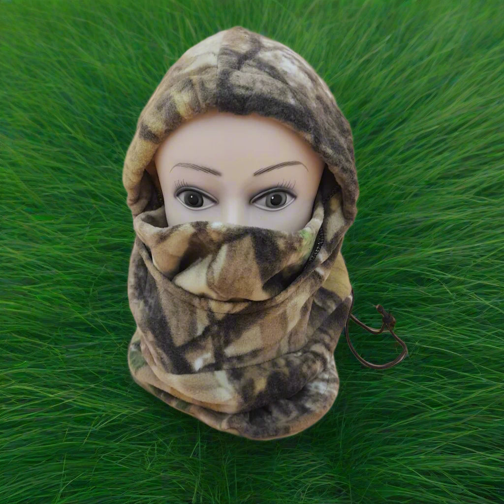 Camouflage balaclava on a mannequin head against a green grass background
