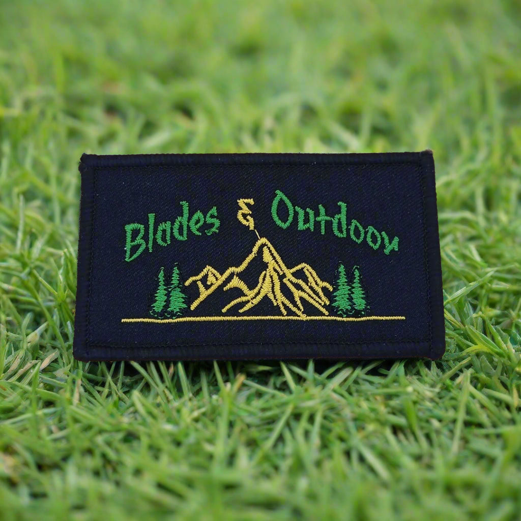A badge with 'Blades & Outdoor' text and a mountain range illustration in green, yellow, and black colors.