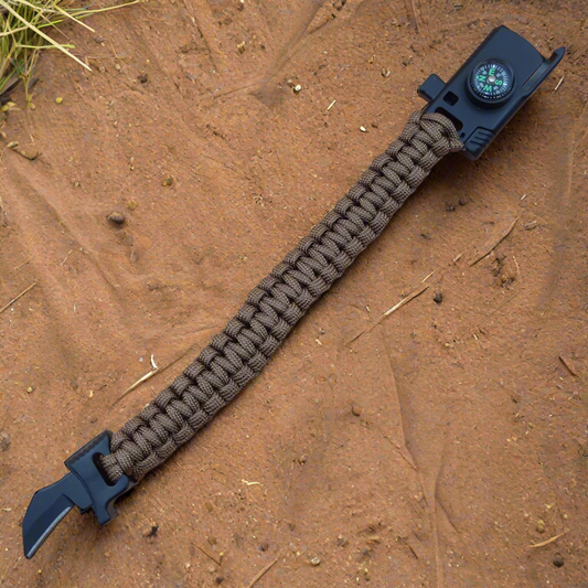 Paracord bracelet with knife and compass on a beige background