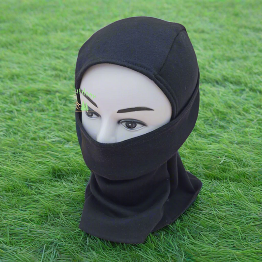 Black headscarf on a mannequin head against a green grass background