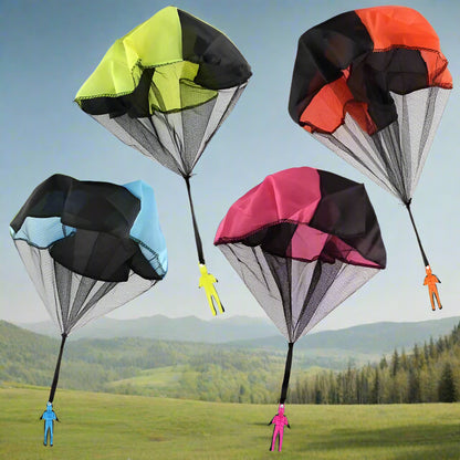 Image shows four toy parachutes in different colors: black, blue, pink, and red, each with a plastic toy soldier attached to the string.