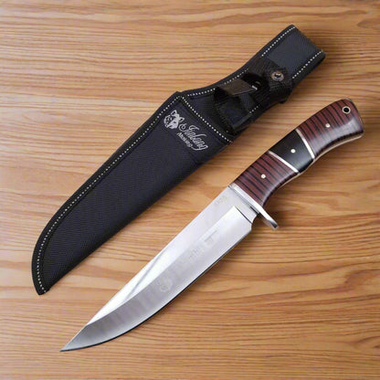 A Columbia brand knife with a black sheath and a wooden handle featuring a striped pattern.
