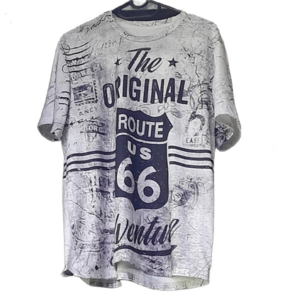 A person wearing a white crew neck T-shirt with text 'The Original Route US 66 Adventure' printed on the front.