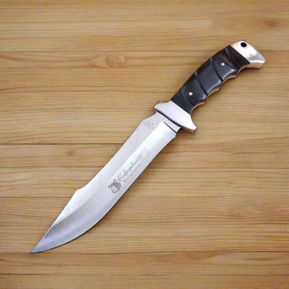 A tactical knife with a black striped handle and a metal blade, marked with the brand Columbia.