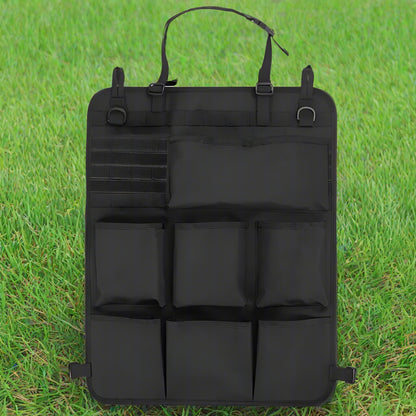 Black car seat organizer with multiple pockets on a grass background