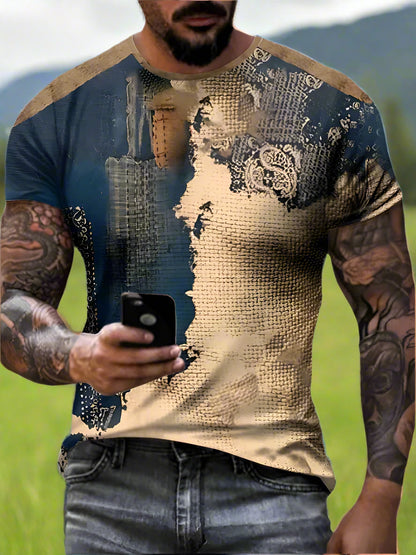 Man wearing a blue and beige patterned t-shirt holding a phone.
