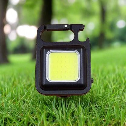 Portable LED work light on grass with a blurred green background
