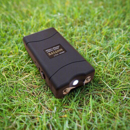 A black colored LED Taser 800 Type with a built-in LED light, displayed on a beige background.
