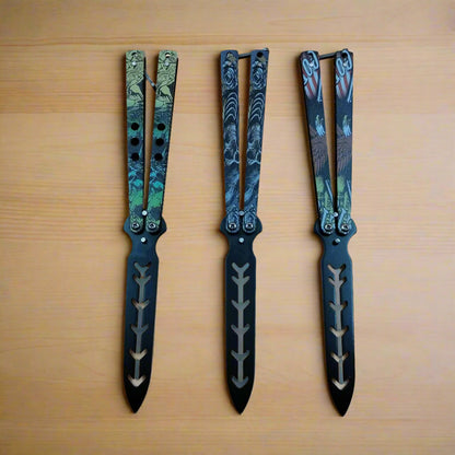 A set of three folding training blades with decorative handles, displayed side by side.