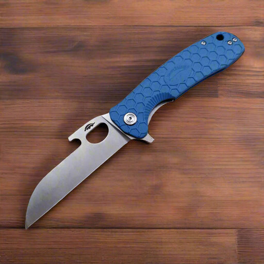 Folding knife with blue handle on a wooden surface