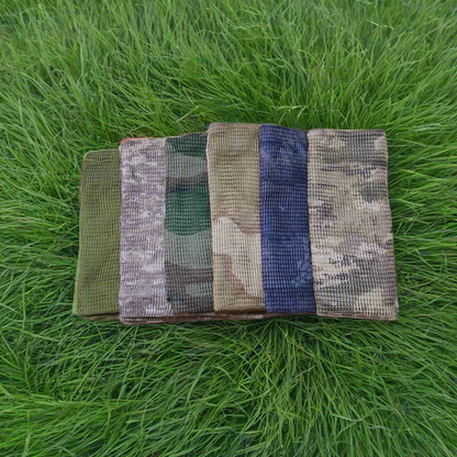 Five camouflage-patterned bags on a forest floor with trees in the background