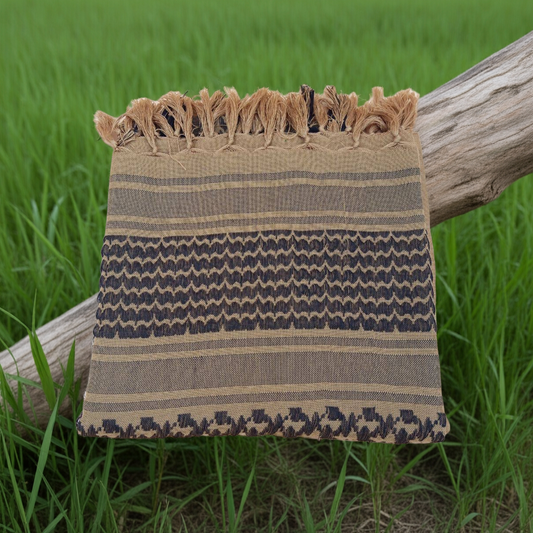 Textile with a pattern draped over a wooden log in a grassy field
