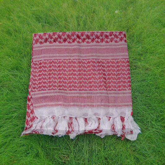 Red and white patterned shemagh surrounded by green grass