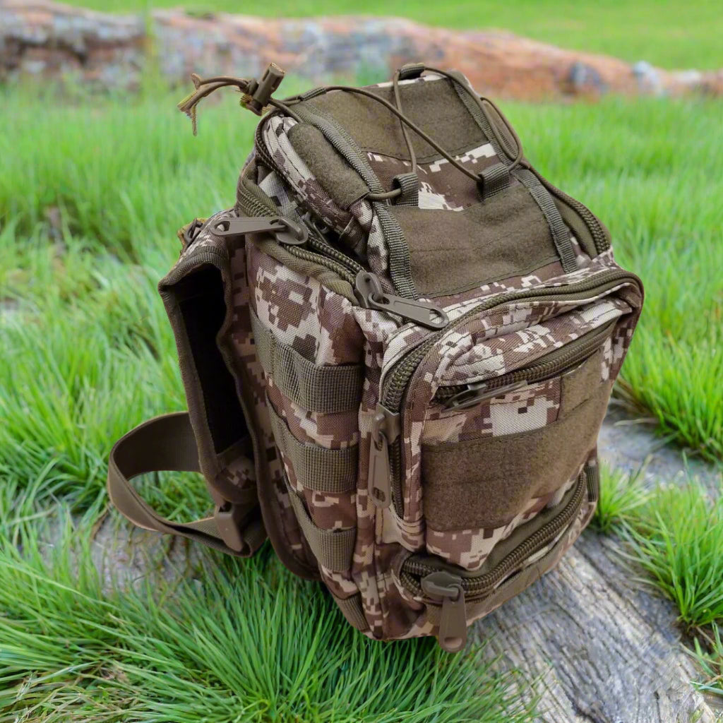 Camouflage backpack on a wooden log with grass in the background