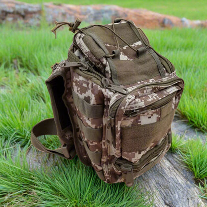Camouflage backpack on a wooden log with grass in the background