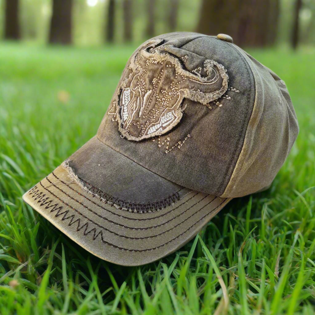 Distressed baseball cap with decorative emblem on a white background