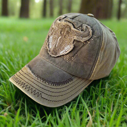 Distressed baseball cap with decorative emblem on a white background